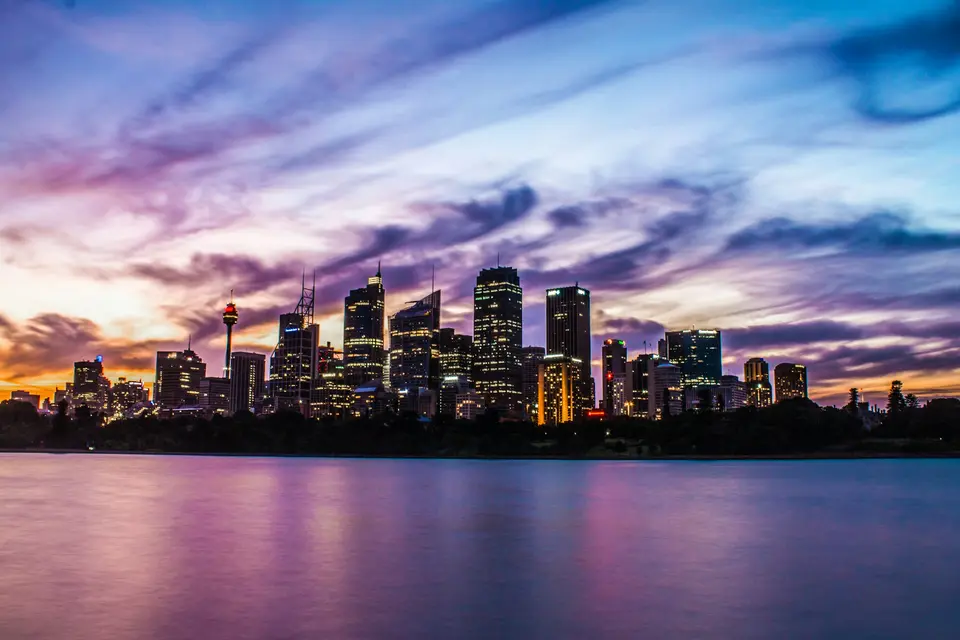 Sydney skyline across the water under a purple sky